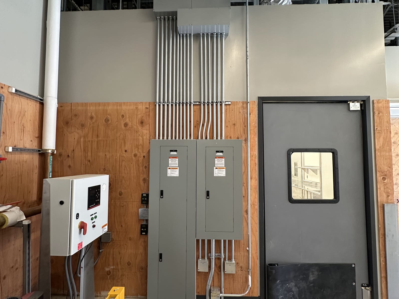 Panelboards and control enclosure in a facility equipment room
